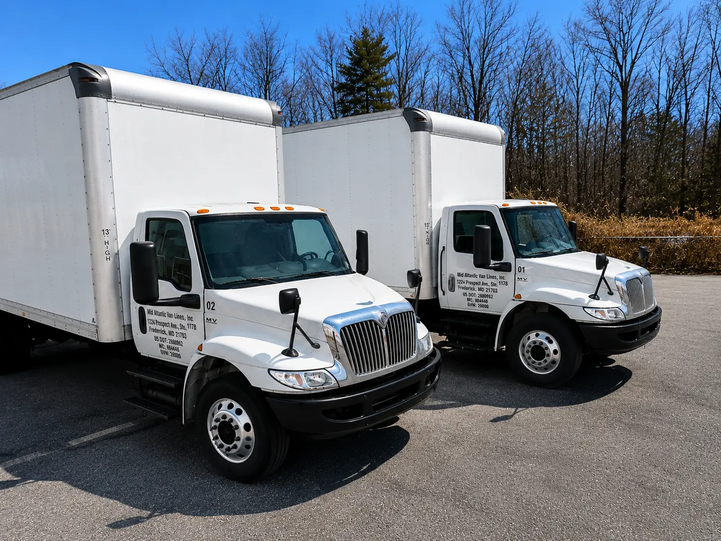 Two Mid Atlantic Van Lines moving trucks parked outdoors